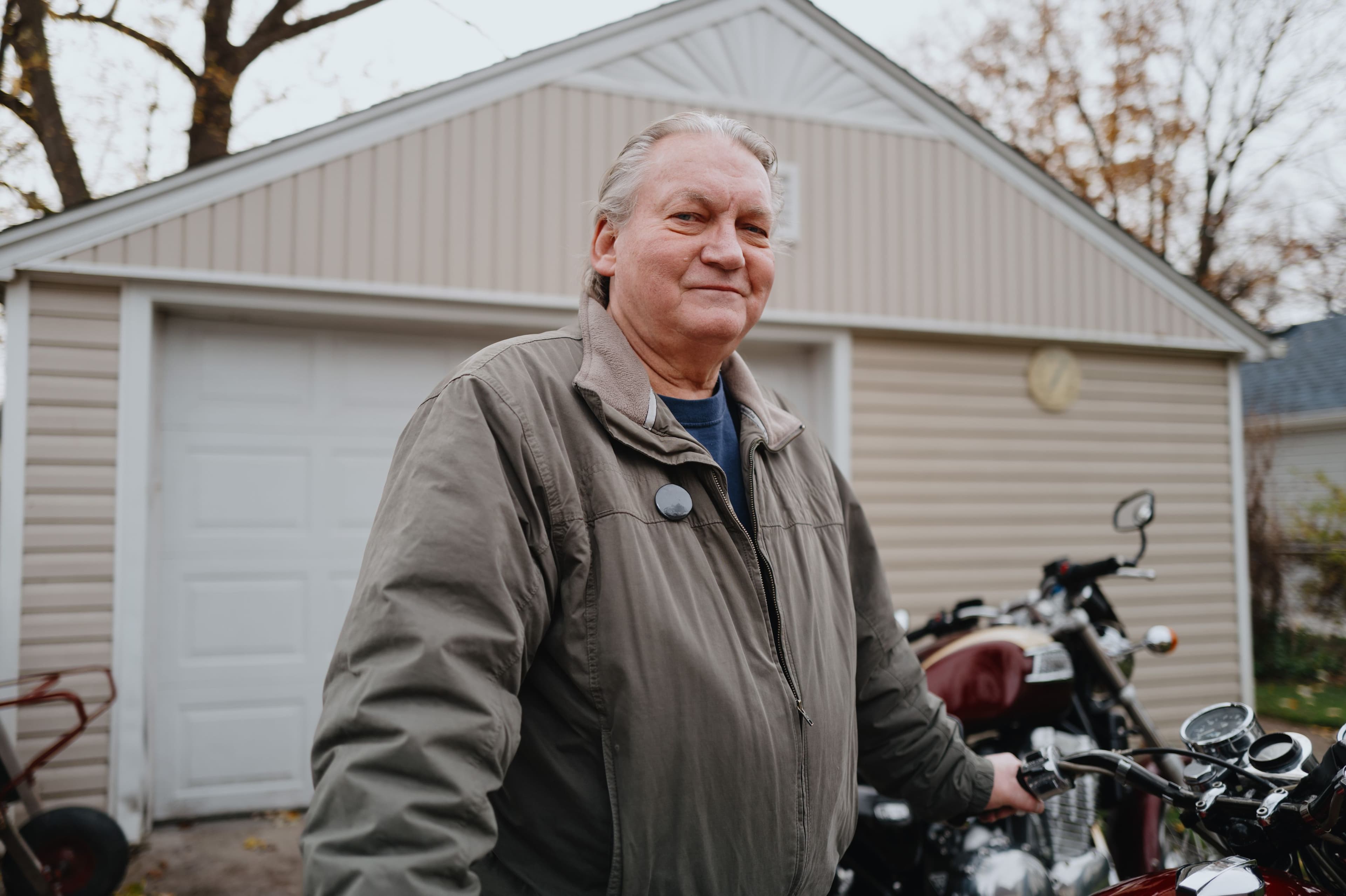 Person standing in front of home and motorcycle