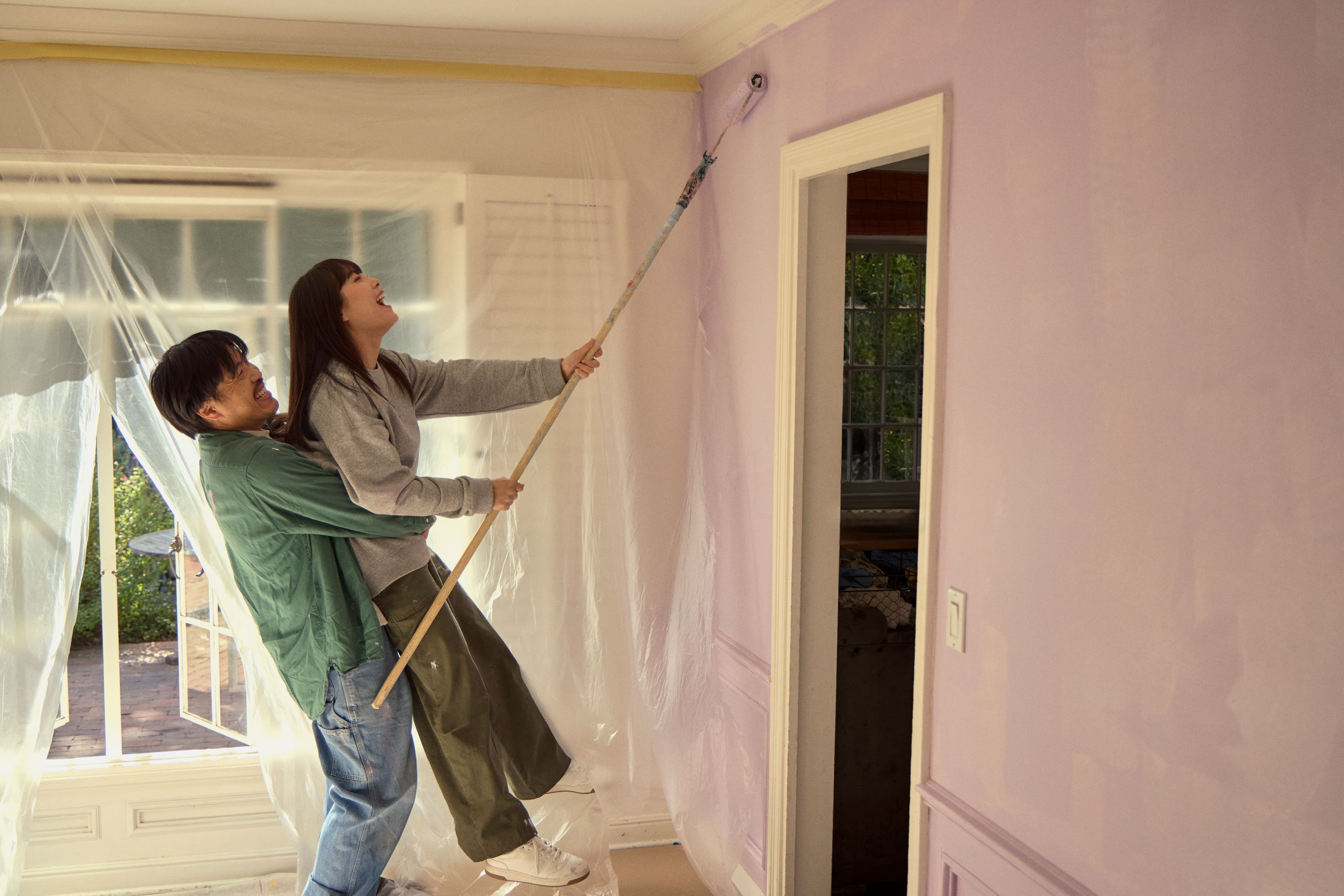Couple painting a wall in their home