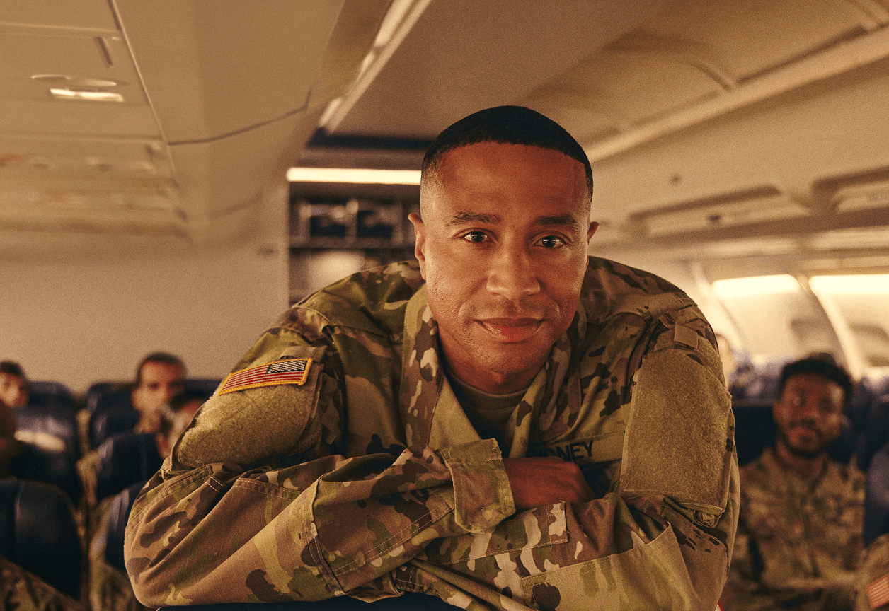 soldier in an airplane seat looking at the camera