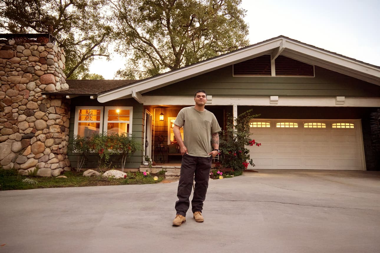 Man outside his home smiling
