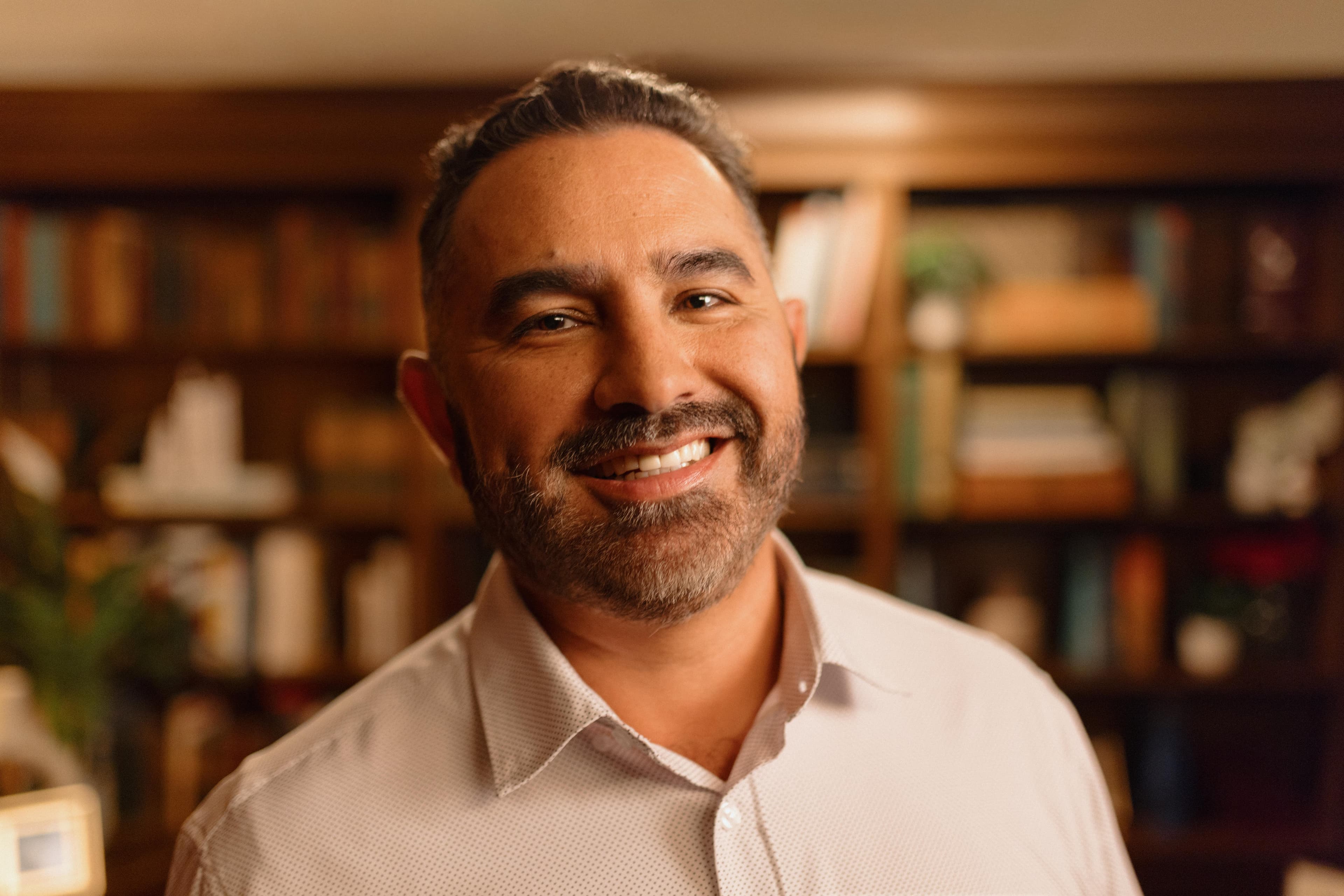 photo of pablo smiling with a bookcase in the background